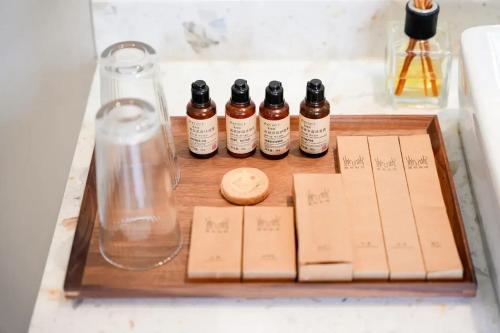 a wooden tray with five bottles of essential oils and a glass at Lu Ming Beiyuan Xi'an Zhongdu Drum Tower City Wall Store in Xi'an