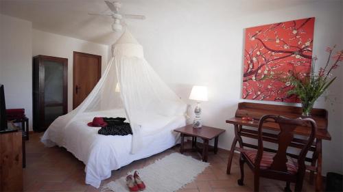 a bedroom with a bed with a mosquito net at Casa Entre Armonías in Zahara de los Atunes