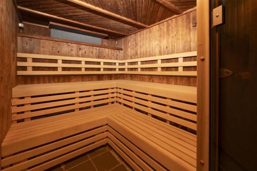 a sauna with wood paneling and a wooden door at Hilton Northampton Hotel in Northampton