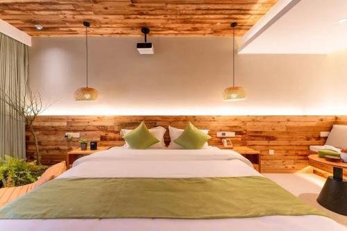 a bedroom with a large bed with green pillows at Lu Ming Beiyuan Xi'an Zhongdu Drum Tower City Wall Store in Xi'an