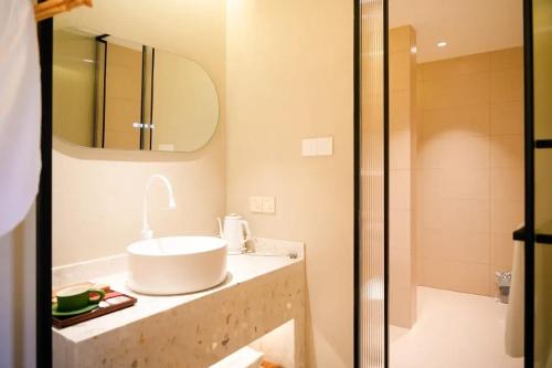 a bathroom with a sink and a shower at Lu Ming Beiyuan Xi'an Zhongdu Drum Tower City Wall Store in Xi'an
