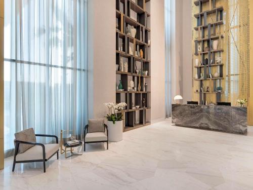 a lobby with two chairs and a reception desk at Fairmont Ramla Serviced Residences in Riyadh