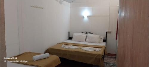 a small room with two beds with towels on them at Casa Beach hut Resort in Palolem