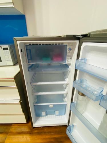 an empty refrigerator with its door open in a room at 3BHK Stay Royal Villa in Mohali in Zirakpur