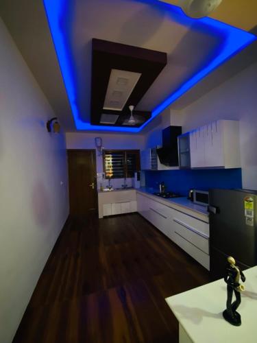a kitchen with a blue light on the ceiling at 3BHK Stay Royal Villa in Mohali in Zirakpur
