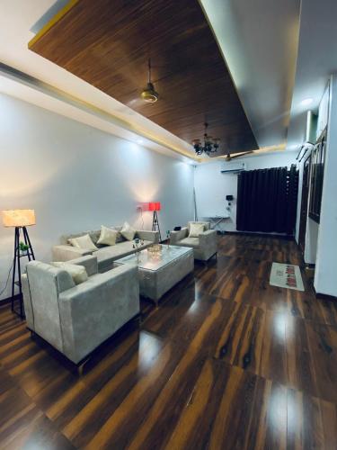 a living room with two couches and a wooden floor at 3BHK Stay Royal Villa in Mohali in Zirakpur