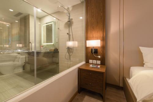 a bathroom with a shower and a bed and a toilet at HD Panorma Nha Trang Free Pool & Gym Condotel in Nha Trang