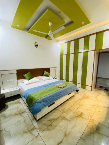 a bedroom with a bed with green and white stripes at 3BHK Stay Royal Villa in Mohali in Zirakpur