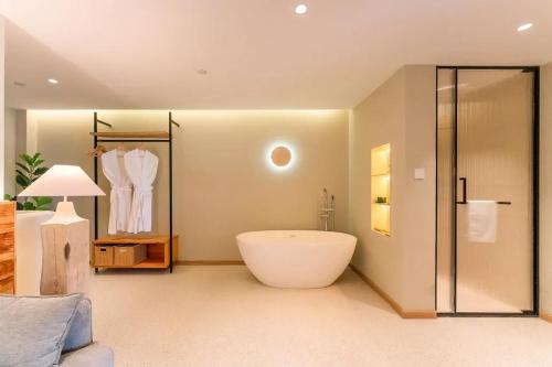 a bathroom with a large tub and a shower at Lu Ming Beiyuan Xi'an Zhongdu Drum Tower City Wall Store in Xi'an