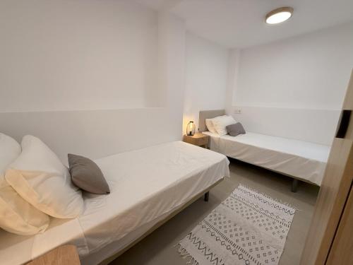 a bedroom with two beds and a rug at NEW - Old Town Modern Apartment Close to Beach in Estepona