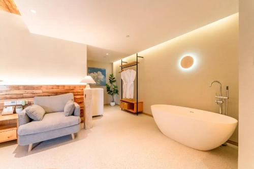 a large bathroom with a large tub and a chair at Lu Ming Beiyuan Xi'an Zhongdu Drum Tower City Wall Store in Xi'an