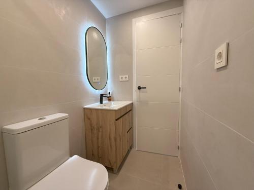 a bathroom with a toilet and a sink and a mirror at NEW - Old Town Modern Apartment Close to Beach in Estepona