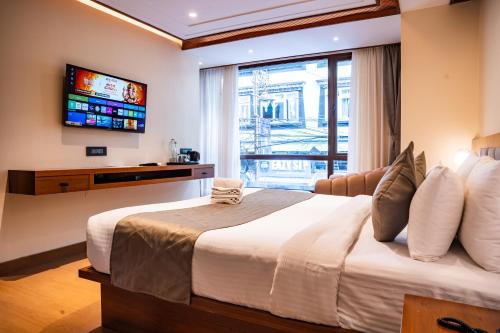 a bedroom with a large bed and a television at Evara Hills, Gangtok in Gangtok