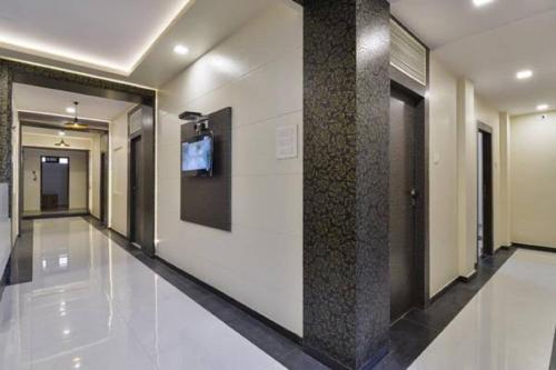 a hallway of a building with a tv on a wall at Hotel Aroma- Dadar in Mumbai