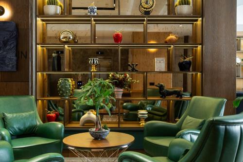 a lobby with green chairs and a table at Alves Hotel in Konak
