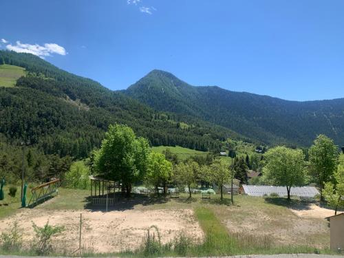a view of a field with mountains in the background at Auberge de jeunesse HI Valdeblore - Le Chalet in Valdeblore