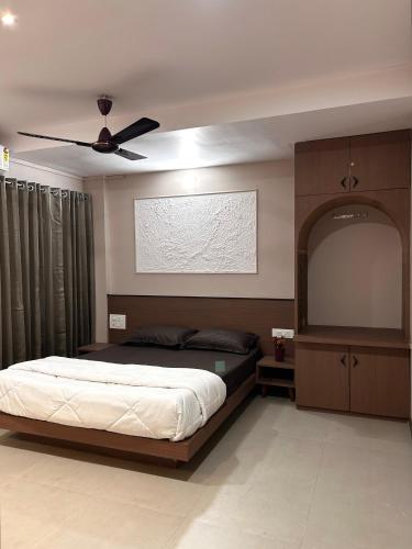 a bedroom with a bed and a ceiling fan at Krushnkunj Executive in Kolhapur