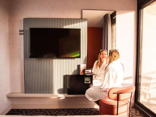 two women sitting in a room with a tv at Tribe Carcassonne in Carcassonne