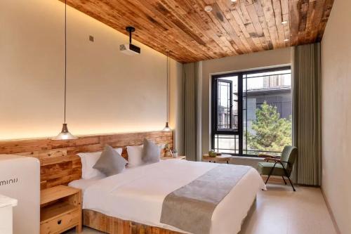 a bedroom with a large white bed and a wooden ceiling at Lu Ming Beiyuan Xi'an Zhongdu Drum Tower City Wall Store in Xi'an