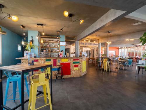 a restaurant with a bar and tables and chairs at greet Hotel Bordeaux Aeroport in Mérignac