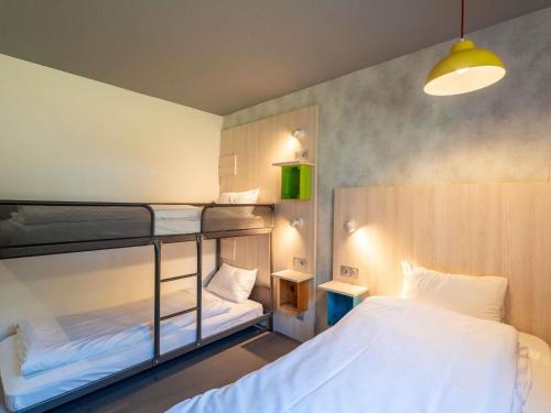 a bedroom with two bunk beds and a lamp at greet Hotel Bordeaux Aeroport in Mérignac