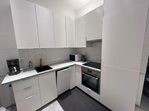 a white kitchen with white cabinets and appliances at L8 Street - Mönsheim in Mönsheim