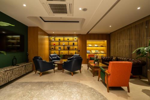 a lobby with chairs and a couch and tables at Alves Hotel in Konak
