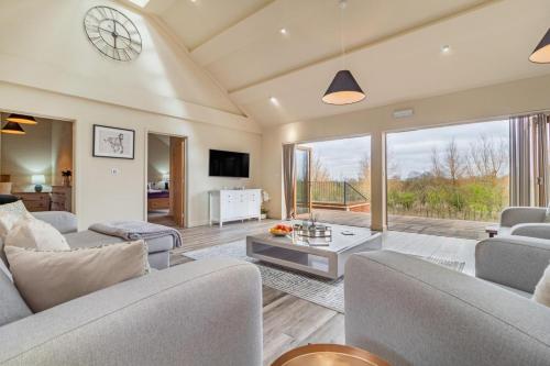 a living room with two couches and a table at White House Lodges - Napier in Heveningham