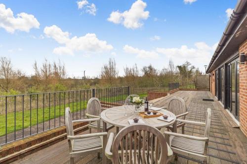 a patio with a table and chairs on a deck at White House Lodges - Napier in Heveningham
