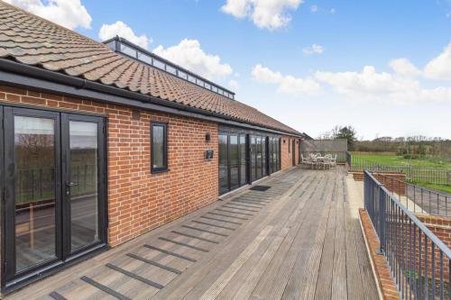 an empty deck of a brick building with windows at White House Lodges - Napier in Heveningham