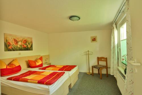 Un dormitorio con dos camas y una silla dentro. en Bungalow Bernstein, en Ostseebad Nienhagen