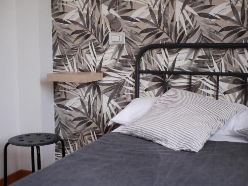 a bedroom with a bed with a tropical wallpaper at Rooms Piramide in Rome