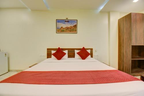 a bedroom with a large white bed with red pillows at Classic Residency in Pune