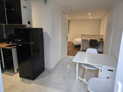 a kitchen with a black refrigerator and a table and chairs at appartement in Lussac-les-Châteaux