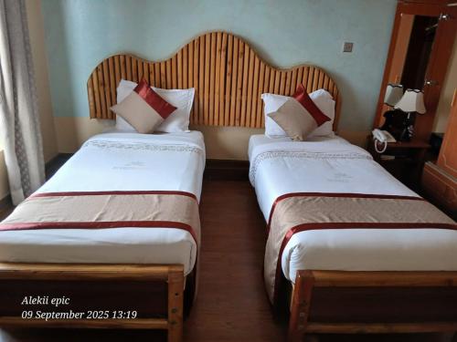 two beds in a hotel room next to each other at Breeze Hotel Nyahururu in Nyahururu