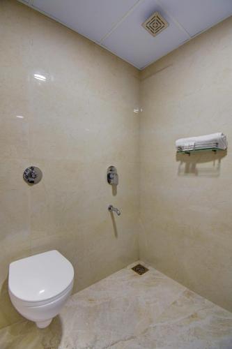 a bathroom with a white toilet in a room at Classic Residency in Pune