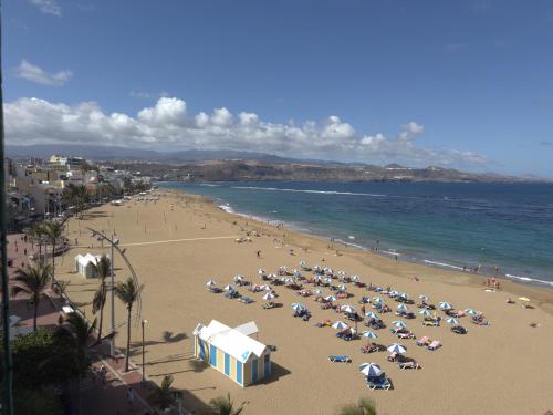 a beach with many umbrellas and people on the beach at Buenavista Las Canteras in Las Palmas de Gran Canaria