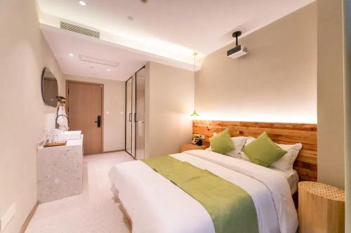 a bedroom with a large bed with green pillows at Lu Ming Beiyuan Xi'an Zhongdu Drum Tower City Wall Store in Xi'an