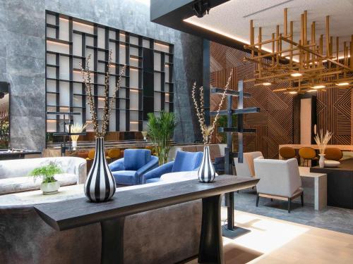 a lobby with a table with blue chairs and a couch at Pullman Lima Miraflores in Lima