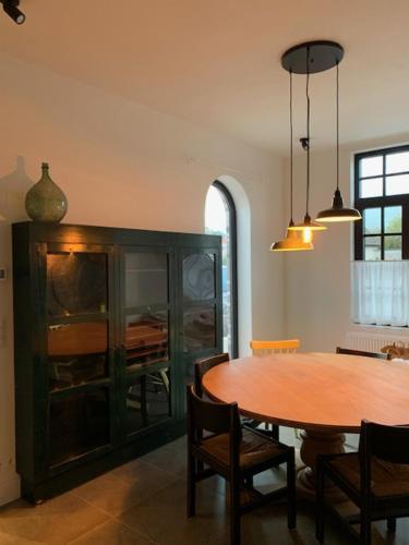 a dining room with a wooden table and a dining room at La Maison Blanche Kaprijke in Kaprijke