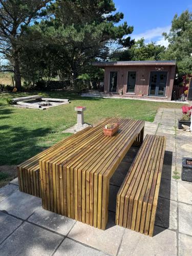 a wooden bench in a yard with a building at 6BR Designer Home OR SEPARATE 2BR Guesthouse OPTION in Fethard on Sea