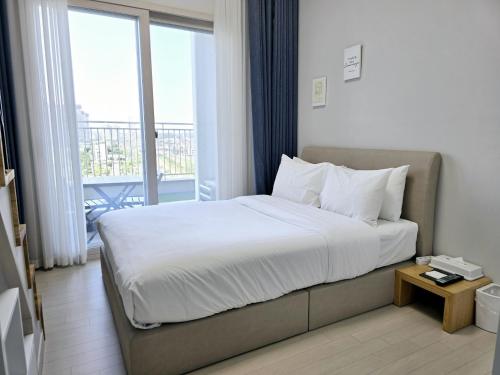 a hotel room with a bed and a balcony at Park View Terrace in Paju