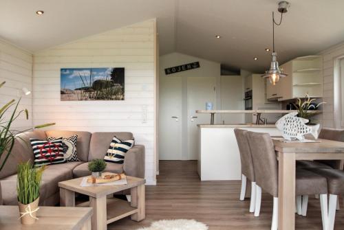 Una cocina y una sala de estar con un sofá y una mesa. en Ostseeferienpark Walkyrien - Kapitän 19, en Kagelbusch