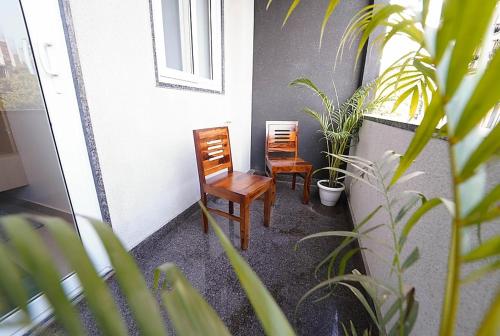two chairs sitting on a porch with plants at Lime Tree Two BHK Service Apartment Golf Course Road Gurgaon in Gurgaon