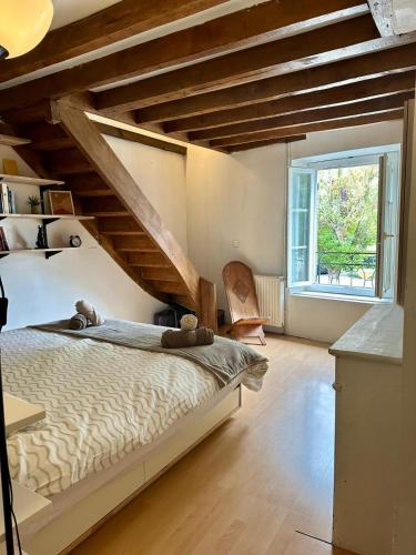ein Schlafzimmer mit einem großen Bett und einem großen Fenster in der Unterkunft Maison cosy pour 2 à Crépy, véranda et jardin in Crépy-en-Valois