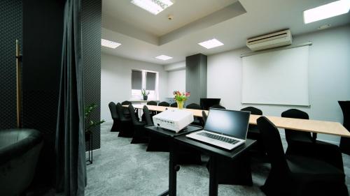 a conference room with a laptop on a table with chairs at Nova Hotel in Radom