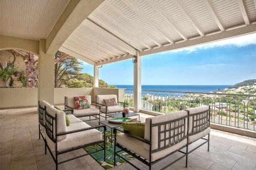 porche con sillas y mesa con vistas al océano en Villa La Doughe, en Santa-Maria-di-Lota