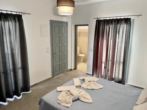 a bedroom with two beds with towels on them at Tarelis Beach Apartments & Studios in Kamari