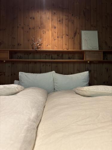 a bed with white sheets and pillows in a bedroom at Landhaus Waldhof am Grossvolderberg in Volders
