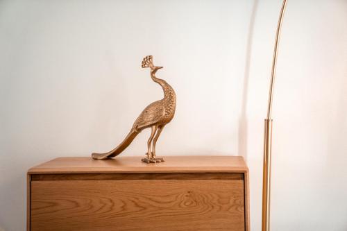 a wooden statue of a bird on top of a dresser at goldfinger + suites in Lana